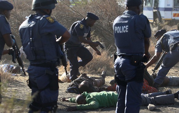 Polizisten bedrohen Streikende in der Lonmin Platinum Mine bei Rustenburg, Südafrika.