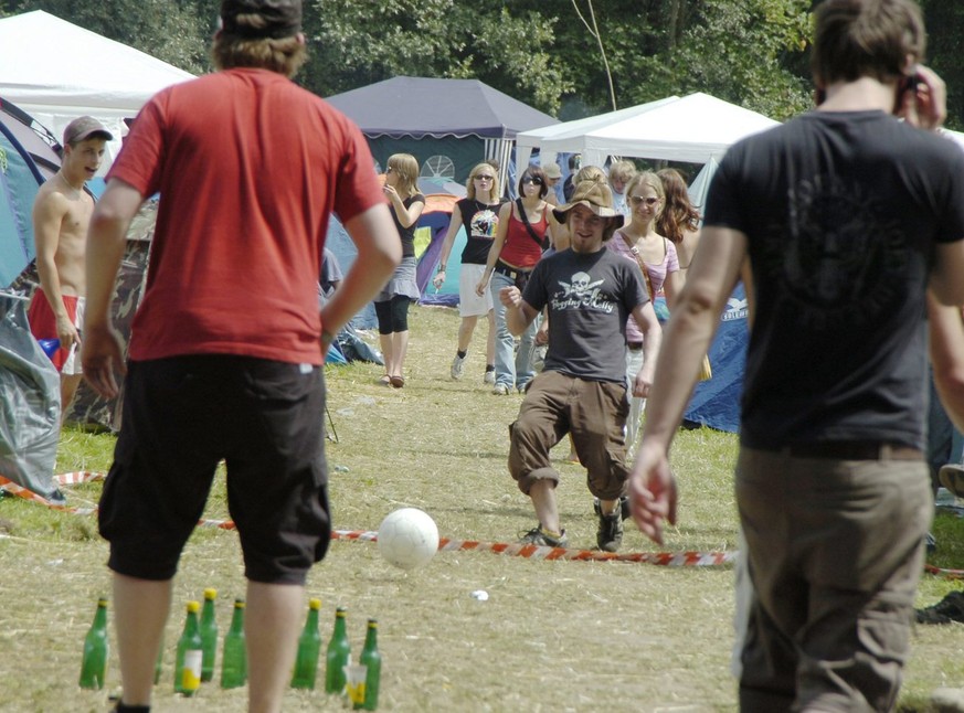 Festivalbesucher spielen eine Art von Bierflaschen-Fussball-Kegeln am Samstag 30. Juni 2007, am Open Air St. Gallen im Sittertobel in St. Gallen. (KEYSTONE/Regina Kuehne)