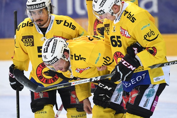 Bern&#039;s Maxime Macenauer, center, leaves the ice injured, with the help of his teammates Eric Blum, left, and Ramon Untersander, right, during the preliminary round game of National League A (NLA) ...
