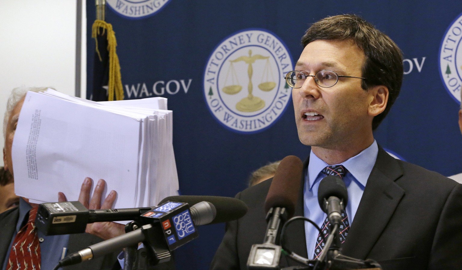 Washington Attorney General Bob Ferguson holds up what he said were 19 reports and studies done since 1992 of vapors escaping from tanks at the Hanford Nuclear Reservation, at a news conference, Wedne ...