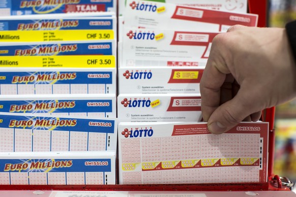 Ein Mann nimmt einen Lotto-Schein aus dem Staender im Emmen Center am Samstag, 3. Dezember 2016, in Emmenbruecke. Im Schweizer Zahlenlotto winkt dem Gluecklichen mit den sechs richtigen Zahlen plus ei ...