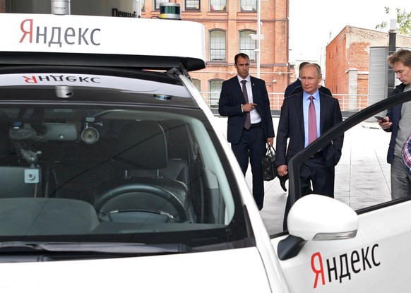 epa06217735 President Vladimir Putin (2-R) attends a demonstration of the prototype of an unmanned car during his visit at Moscow office of the IT company Yandex in Moscow, Russia, 21 September 2017.  ...