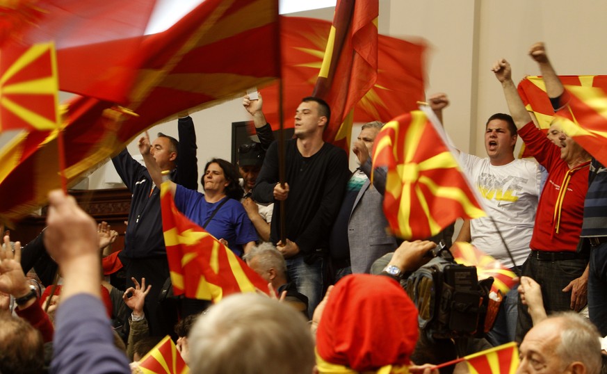Protestors wave national flags after entering into the parliament building in Skopje, Macedonia, Thursday, April 27, 2017. Scores of protesters have broken through a police cordon and entered Macedoni ...