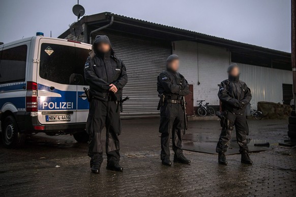 epa05631905 Police officers stand guard in front of a warehouse during a search in Pulheim, Germany, 15 November 2016. Several police officers took part in an anti-terrorism raid against suspected sup ...