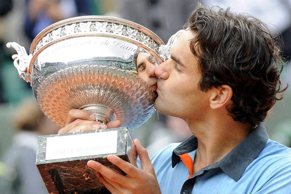 epa01754654 Switzerland&#039;s Roger Federer celebrates with the trophy after winning the final match against Sweden&#039;s Robin Soderling in the French Open tennis tournament at Roland Garros in Par ...