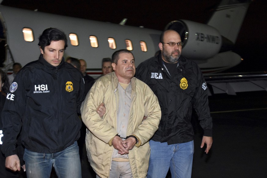 FILE - In this Jan. 19, 2017 file photo provided U.S. law enforcement, authorities escort Joaquin &quot;El Chapo&quot; Guzman, center, from a plane to a waiting caravan of SUVs at Long Island MacArthu ...