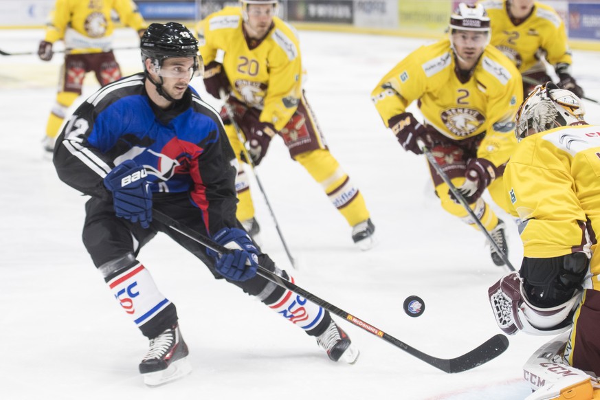 Zuerichs Luca Cunti, links, kaempft um den Puck gegen Servettes Torhueter Robert Mayer, rechts, beim Eishockeyspiel der Nationalleague A ZSC Lions gegen den Geneve-Servette HC im Hallenstadion in Zuer ...