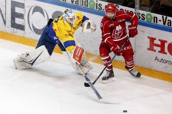 Le gardien davosiens Gilles Senn, gauche, lutte pour le puck avec l&#039;attaquant lausannois Benjamin Antonietti, droite, lors du 1er match du quart de finale de play off du championnat suisse de hoc ...