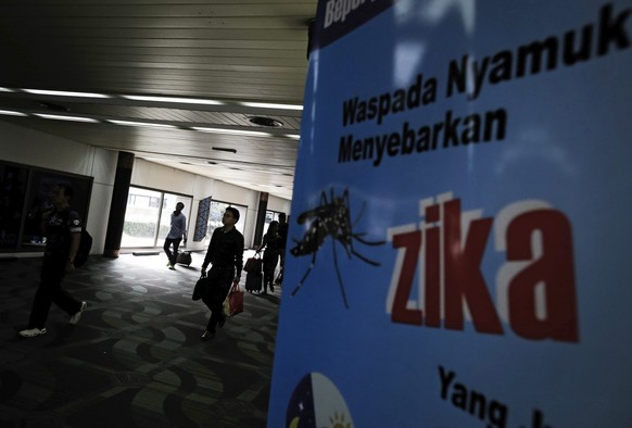 epa05519775 Arriving passangers walk past a banner with writing &#039;Be ware mosquito spreads Zika&#039; at Soekarno-Hatta International Airport in Tangerang, outskirt of Jakarta, Indonesia, 02 Septe ...