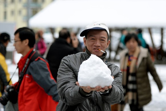 Ein chinesischer Tourist freut sich über den Schnee in der Schweiz.