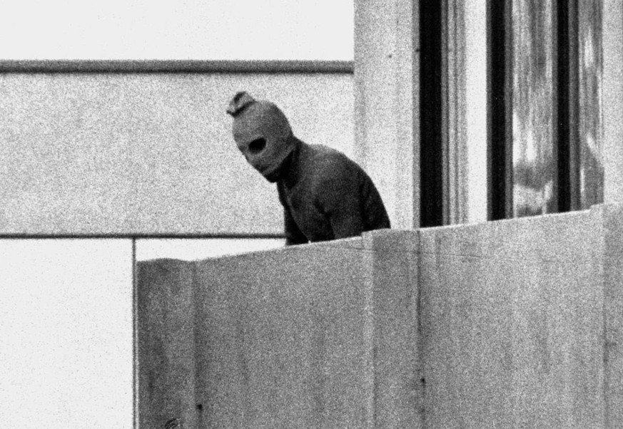 A member of the Arab Commando group which seized members of the Israeli Olympic Team at their quarters at the Munich Olympic Village September 5, 1972 appears with a hood over his face on the balcony  ...