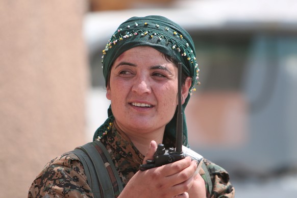A female Kurdish fighter from the People&#039;s Protection Units (YPG) carries a walkie-talkie as she stands in the Ghwairan neighborhood of Hasaka, Syria, August 22, 2016. REUTERS/Rodi Said