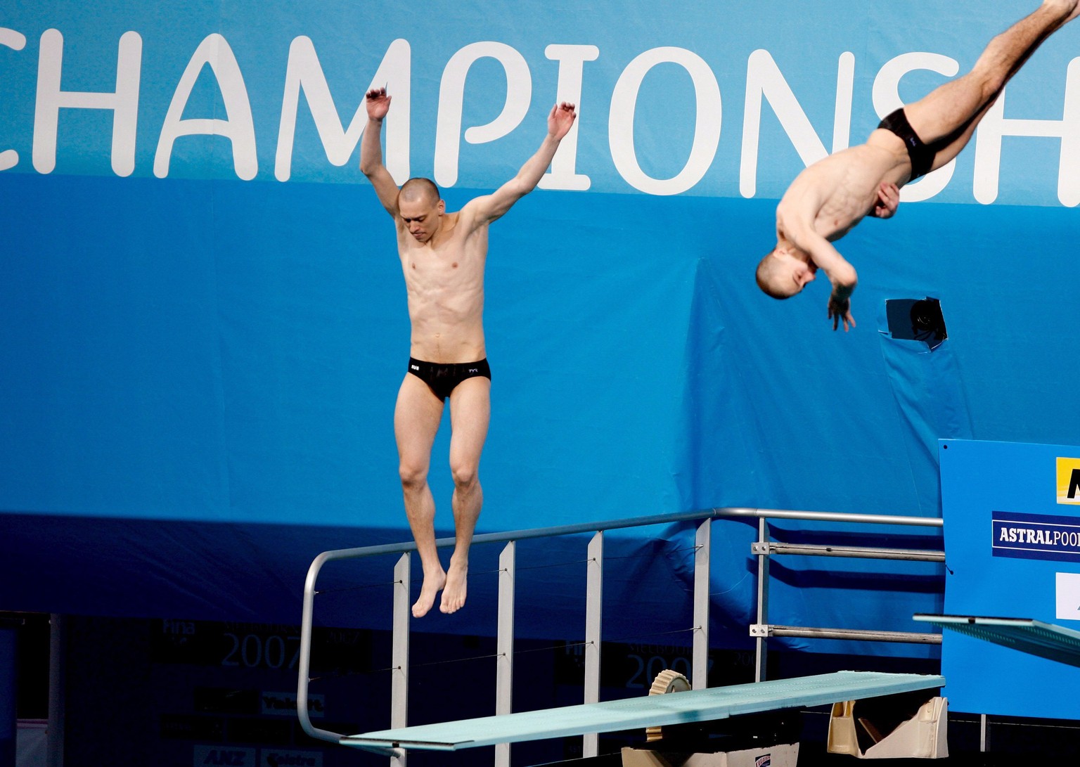 epa00960762 Russian diver Aleksander Dobroskok jumps but fails to dive a his synchronised diving partner Gleb Galperin (R) dives dashing their lead in the men's 3m synchro springboard finals at t ...