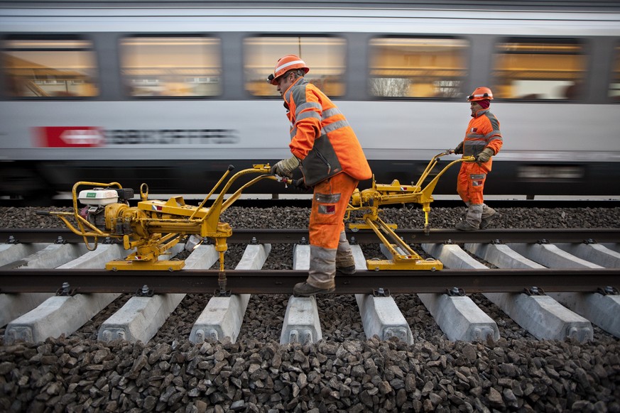 ZUM NACHHOLBEDARF BEIM UNTERHALT DES SBB-SCHIENENNETZES STELLEN WIR IHNEN FOLGENDES BILDMATERIAL ZUR VERFUEGUNG - Gleismonteure des Bauunternehmens Vanoli fixieren am fruehen Morgen des 10. Aprils 201 ...