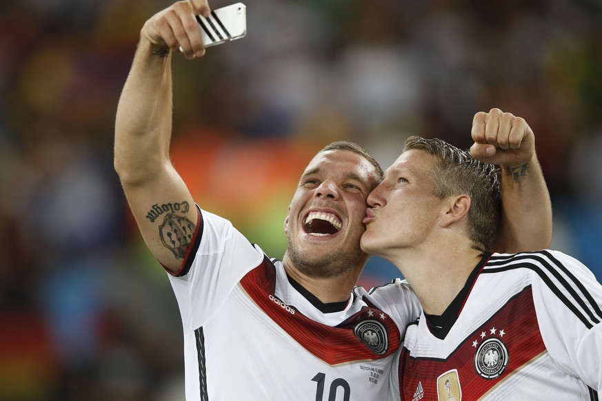 Sehen Sie den Unterschied? Podolski trägt noch das «alte» Trikot mit drei Weltmeister-Sternen auf der Brust, während Schweinsteiger schon ins neue geschlüpft ist.