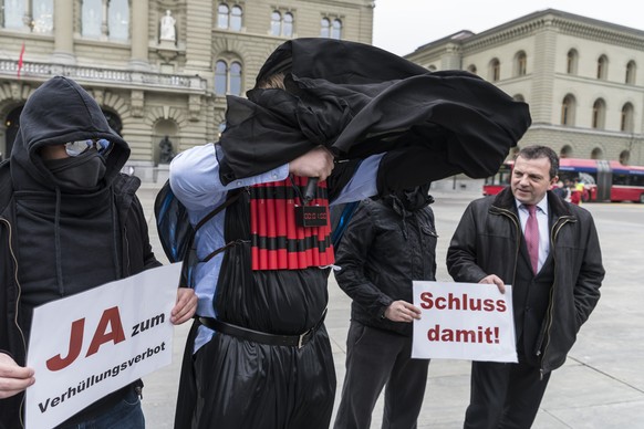 SVP-Nationalrat Walter Wobmann, SO, rechts, posiert mit Statisten, die sich als burkatragende Terroristen und Vermummte inszenieren, zur Lancierung der Unterschriftensammlung zur Initiative fuer ein V ...