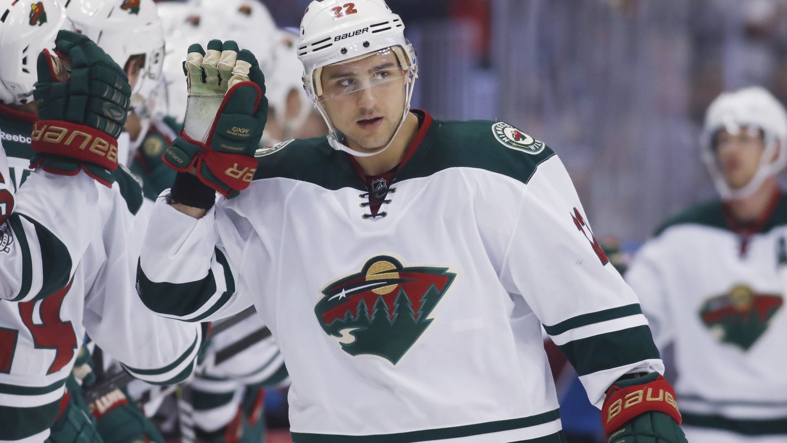 Minnesota Wild right wing Nino Niederreiter, of the Czech Republic, is congratulated as he passes the team box after scoring against the Colorado Avalanche during the third period of an NHL hockey gam ...