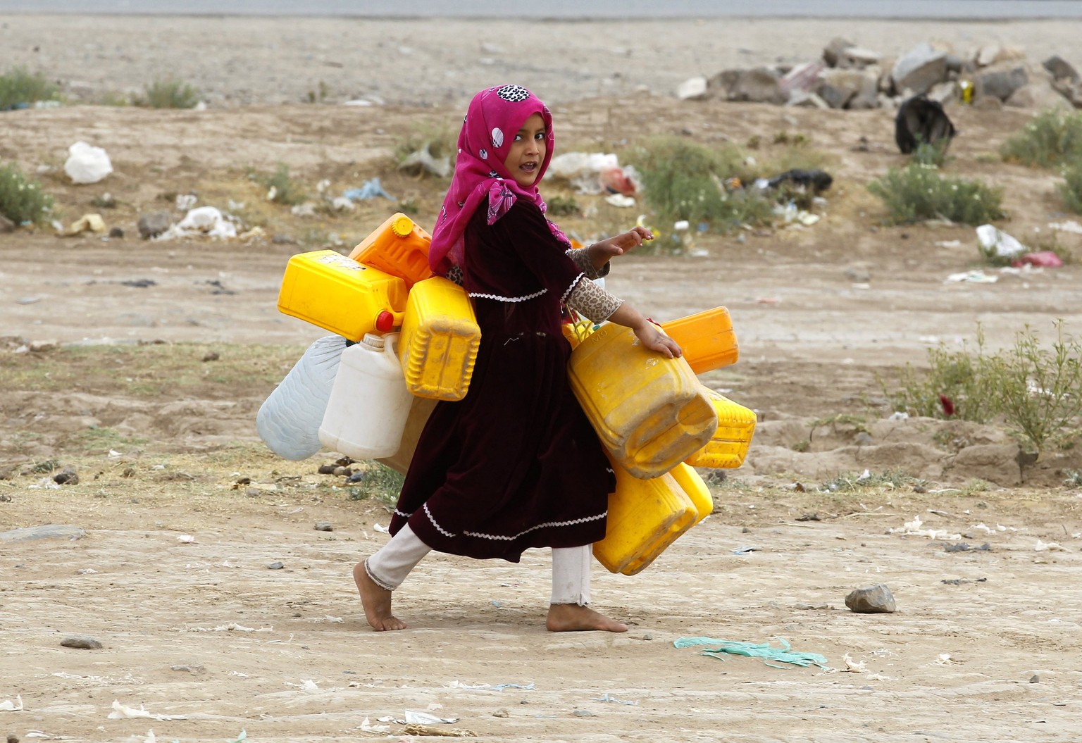 epa05864165 A Yemeni girl carries empty jerry-cans before collecting water from a donated water-tap, on the World Water Day, on the outskirts of Sana&#039;a, Yemen, 22 March 2017. World Water Day is h ...