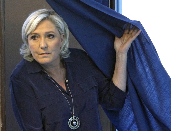 French far-right presidential candidate, Marine Le Pen exits a voting booth before casting her ballot in Henin Beaumont, Northern France, Sunday, June 11, 2017. French voters are choosing lawmakers in ...