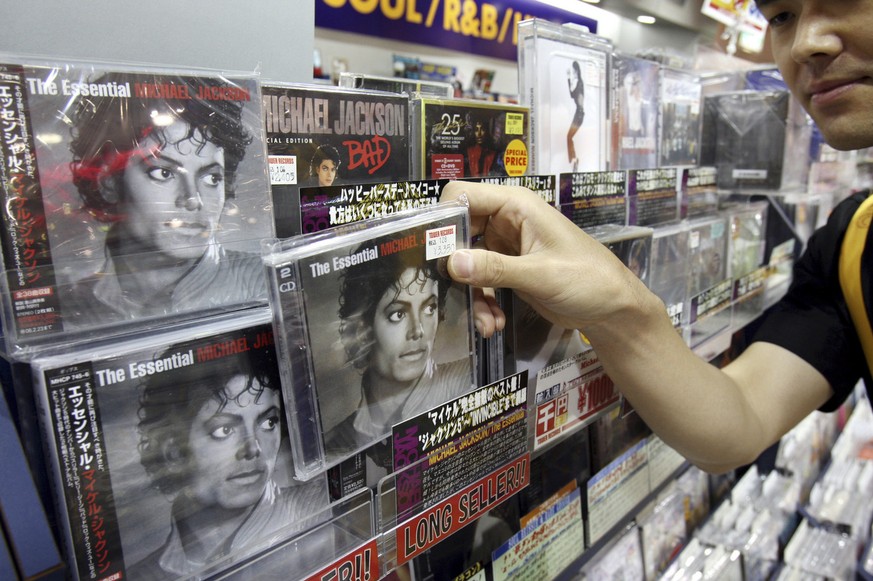 Tower Records Japan employee Ryosuke Kawada shows a CD of Michael Jackson at a store in Tokyo, Japan, Friday, June 26, 2009. Tower Records stores around Tokyo set up special Michael Jackson sections i ...