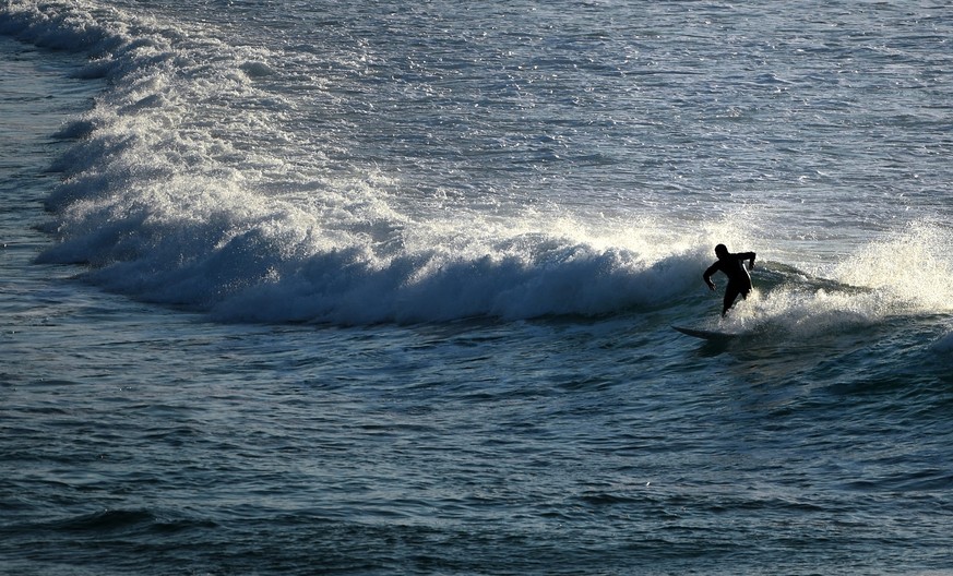 epa04965090 A surfer is seen at Bondi Beach in Sydney, Australia, 06 October 2015. Sydney is facing another scorching day on 06 October as a big high pressure system steers unusually warm winds over t ...