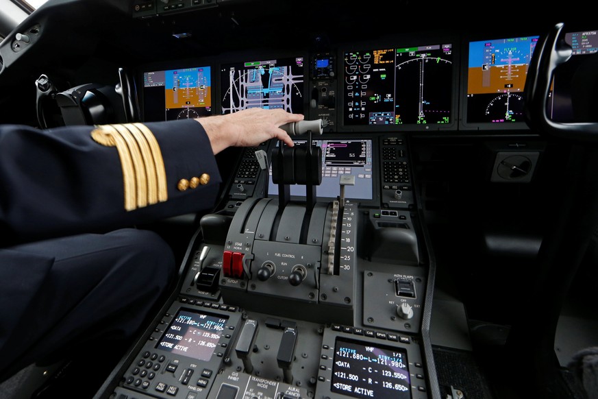 An Air France pilot stands in the cockpit of the airline&#039;s new Boeing Inc. 787-9 Dreamliner passenger aircraft as it stands on the tarmac at Charles de Gaulle Airport in Roissy, France, December  ...