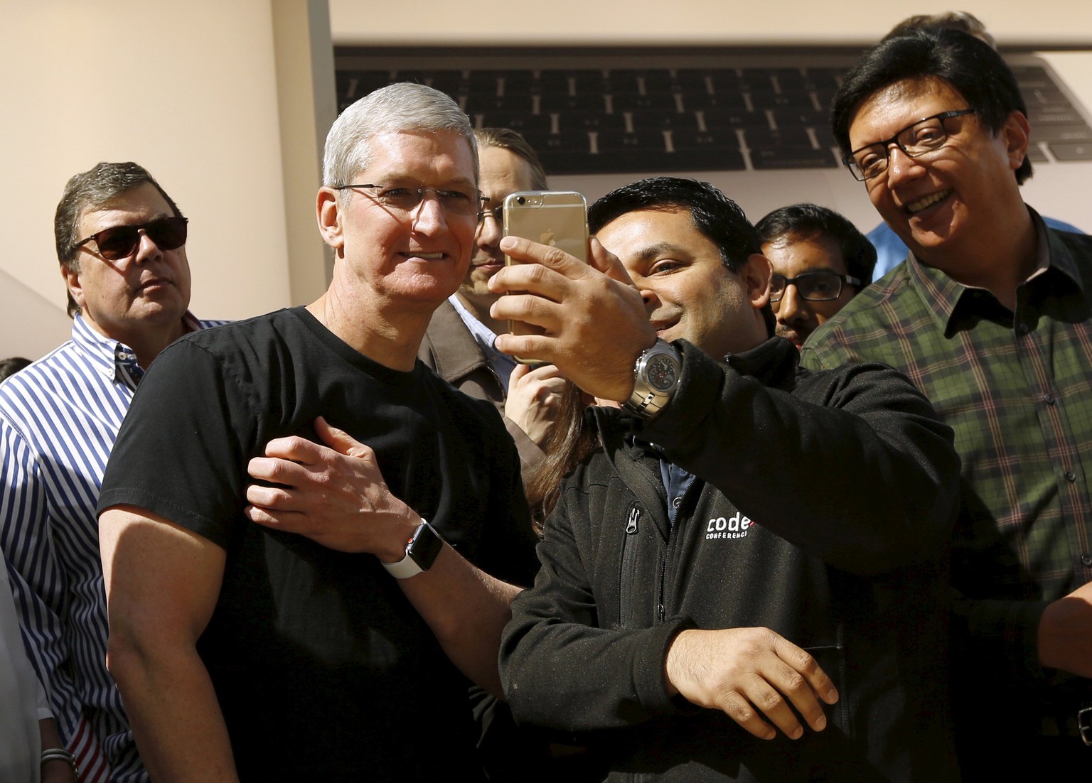 Apple CEO Tim Cook displays his Apple Watch while having a photograph taken by a customer in Palo Alto, California April 10, 2015. Customers flocked to Apple Inc&#039;s stores around the world on Frid ...