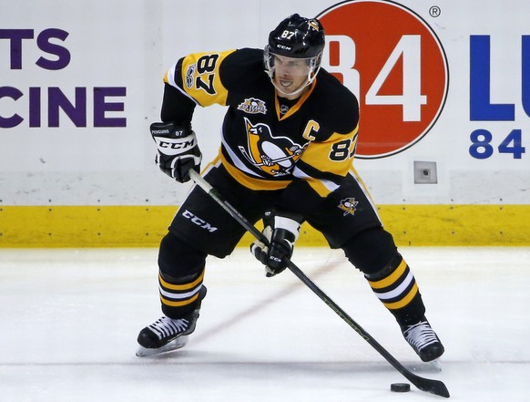 Pittsburgh Penguins&#039; Sidney Crosby looks to pass to Jake Guentzel, ending up with an assist on Guentzel&#039;s goal during the third period of the team&#039;s NHL hockey game against the Vancouve ...