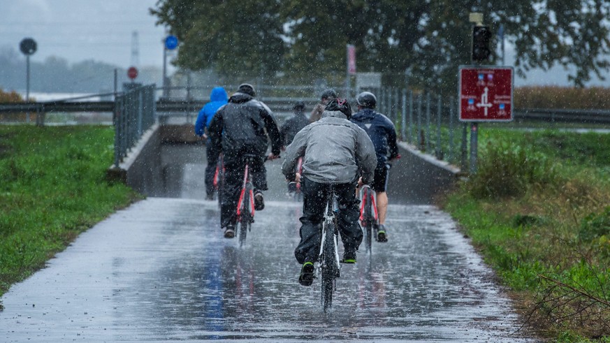 epa04445175 Cyclist ride during heavy rain in Riazzino near Locarno in the Canton of Ticino, southern Switzerland, 13 October 2014. In the night from 12 to 13 October up to 100 liters of rain per squa ...