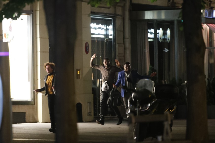 epa05918187 French people hold their hands in the air after a shooting in which two police officer were killed along with their attacker and another police officer wounded in a terror attack on the Ch ...