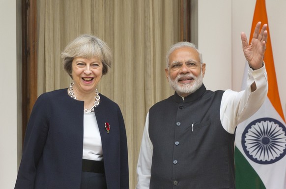 Indian prime Minister Narendra Modi, right, waves to media as his British counterpart Theresa May watches before their meeting in New Delhi, India, Monday, Nov. 7, 2016. Modi and May have begun wide-r ...