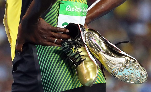 epa05495147 Usain Bolt of Jamaica carries his shoes after competing during the men&#039;s 200m semi finals of the Rio 2016 Olympic Games Athletics, Track and Field events at the Olympic Stadium in Rio ...