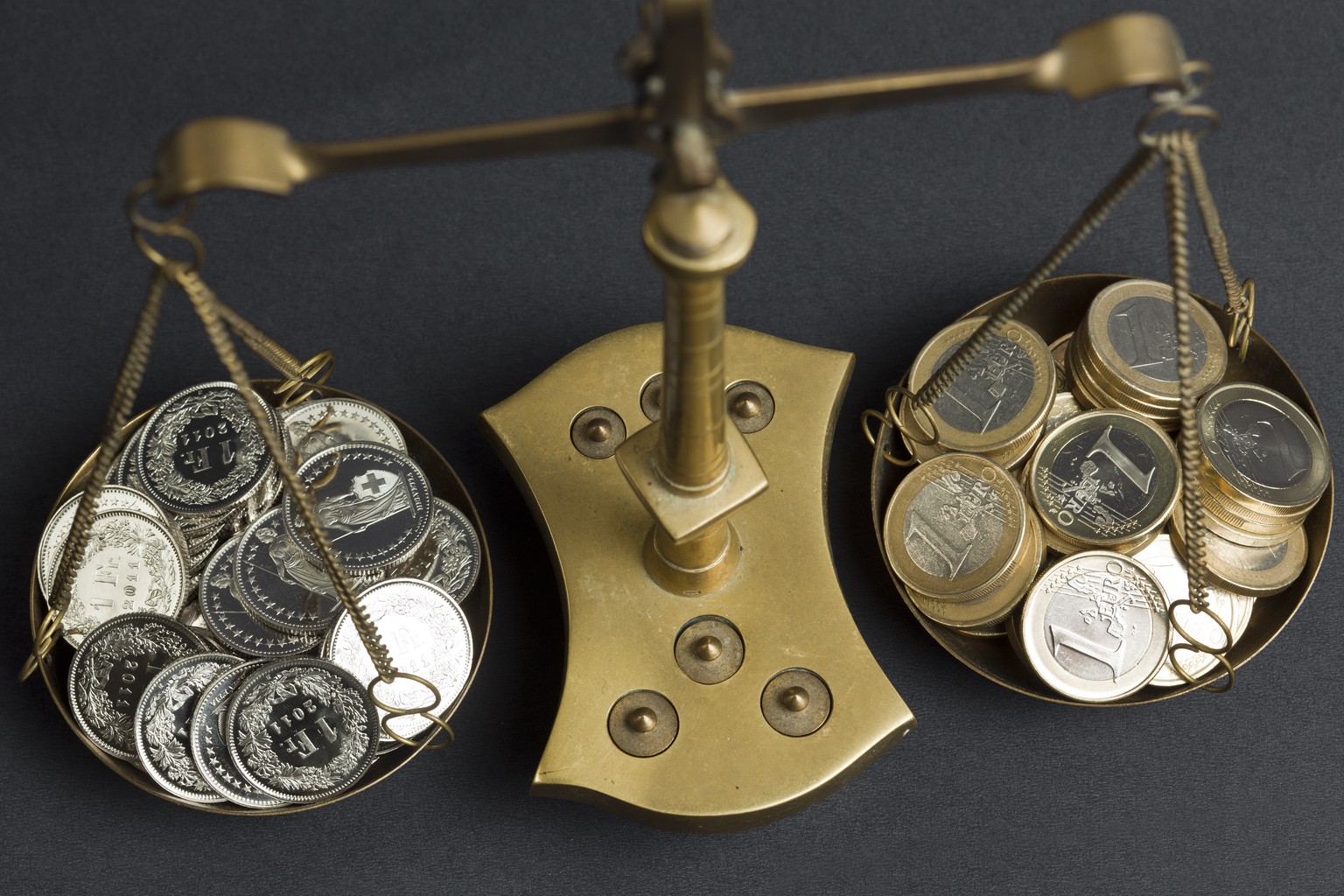 ARCHIVBILD - EURO UEBERSCHREITET ZUM ERSTEN MAL SEIT JANUAR 2015 DIE MARKE VON 1,15 FRANKEN - A pair of balances filled with coins of 1 Swiss Franc (left) and coins of 1 Euro (right), pictured on July ...