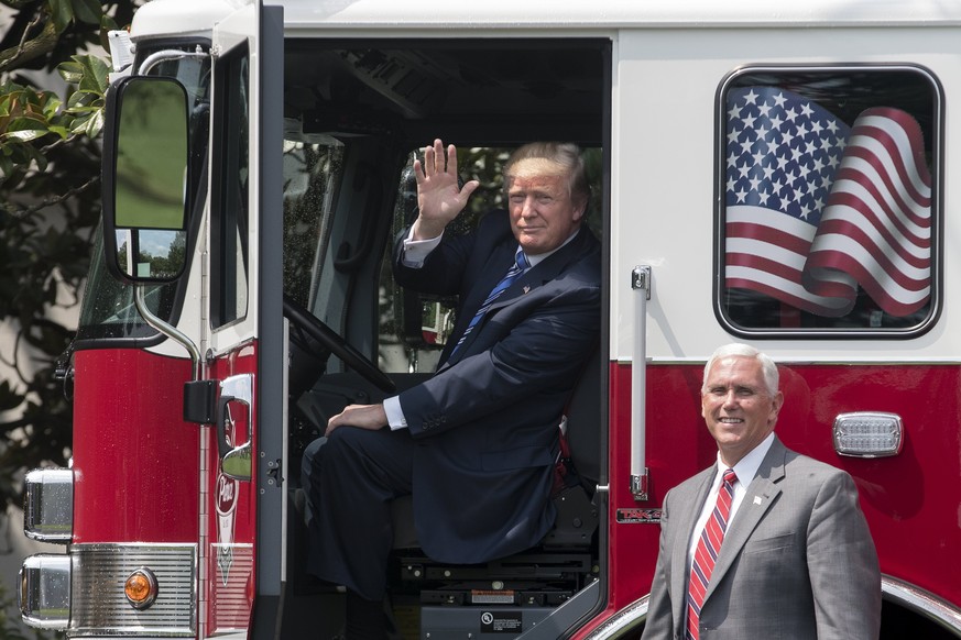 epa06093591 US President Donald J. Trump (L) sits in a firetruck from Wisconsin, beside US Vice President Mike Pence (R) while participating in a showcase of products made in the United States, at the ...