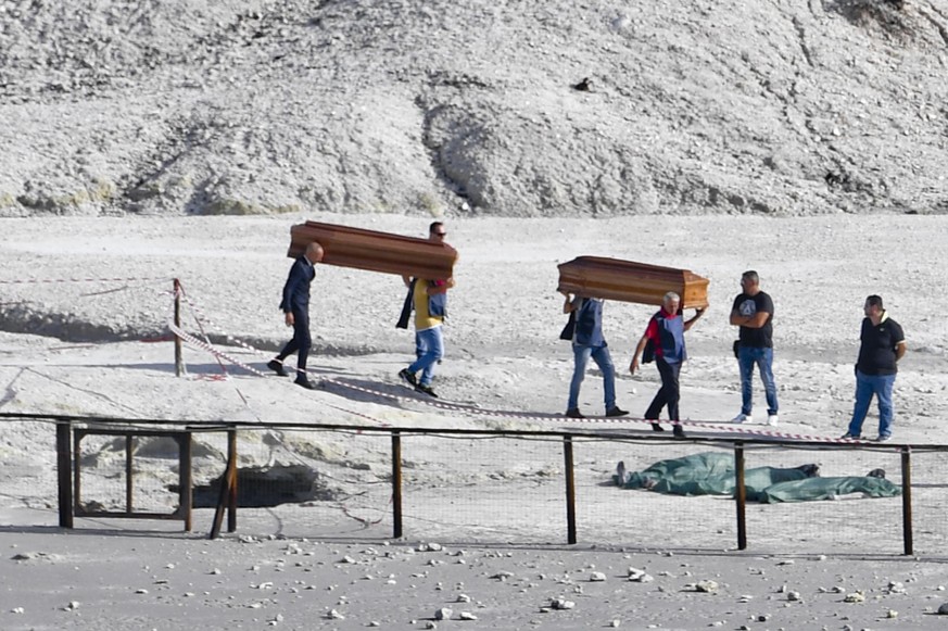 epa06200372 The coffins of three dead people are carried away out of the volcanic zone, where three people died in the crater at Pozzuoli, Naples, Italy, 12 September 2017. A couple and an 11-year-old ...