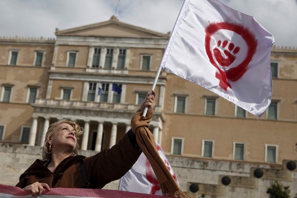 A woman waves a flag depicting a symbol of feminism during a march to celebrate International Women&#039;s Day in Athens March 8, 2014. On March 8 activists around the globe celebrate International Wo ...
