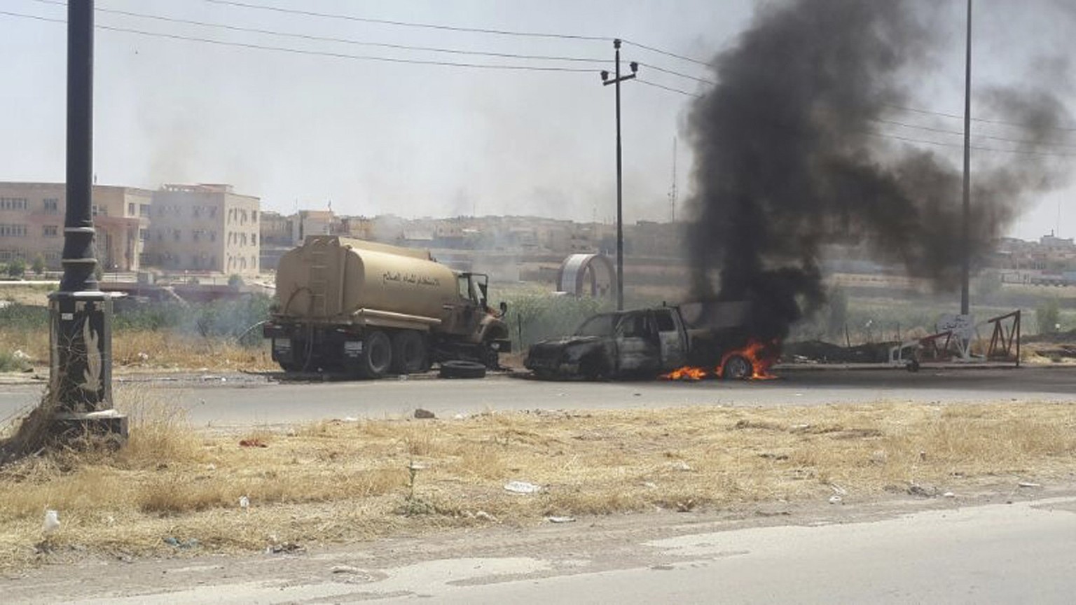 Fahrzeuge der irakischen Sicherheitskräfte in Mossul stehen in Flammen.