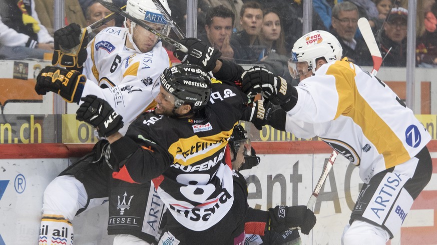 LuganoÕs Massimo Ronchetti, Berns Thomas Ruefenacht, Berns Simon Moser, und LuganoÕs Julien Vauclair, von links, kaempfen um den Puck, beim Eishockey Meisterschaftsspiel der National League zwischen d ...