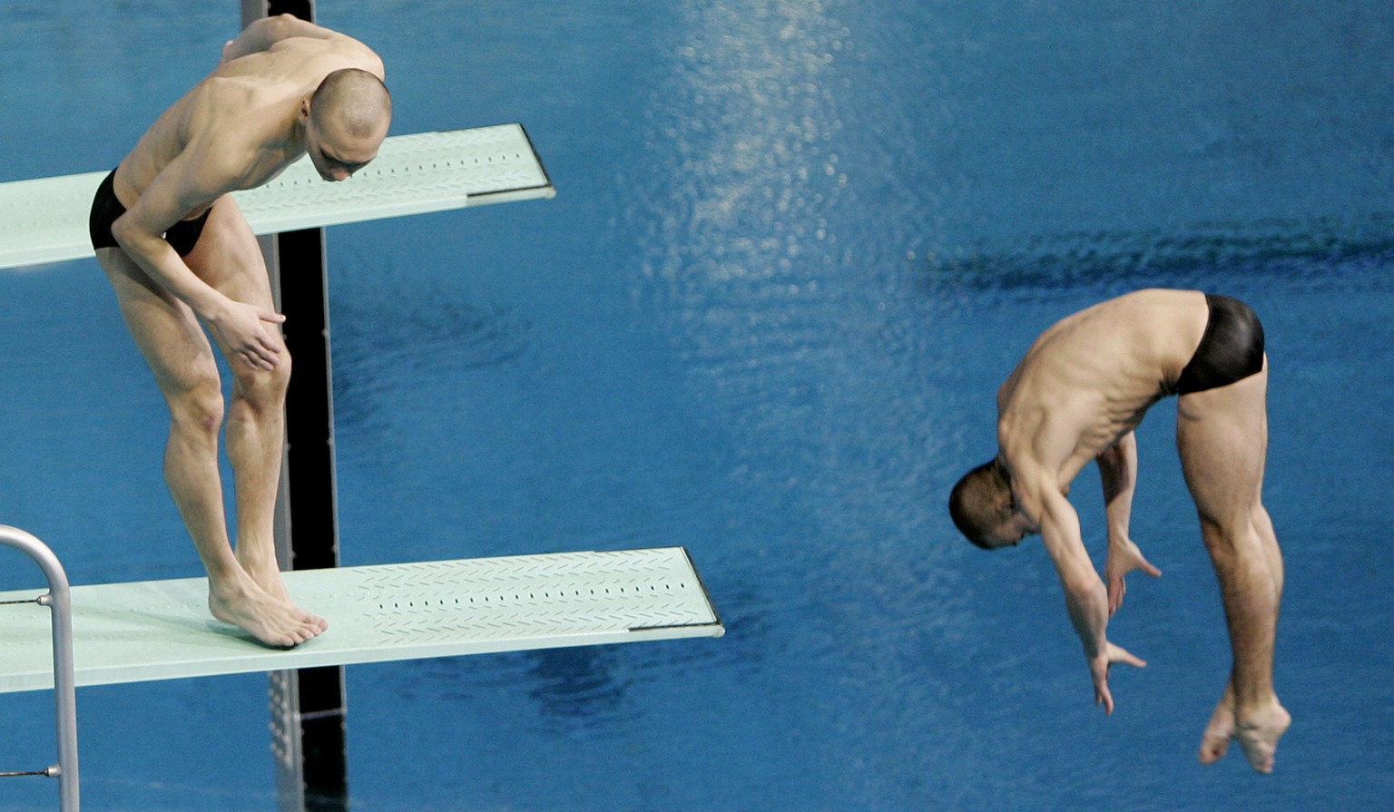 Russian diver Aleksandr Dobroskok left, fails to dive as partner Gleb Galperin completes their routine during the final of the men's 3-meter synchro springboard event at the World Swimming Champi ...