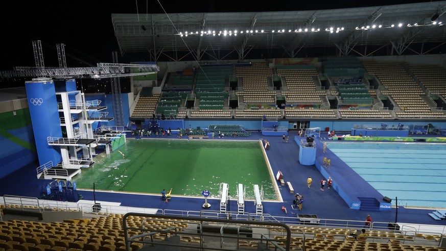 The water of the diving pool at left appears a murky green, in stark contrast to the pool&#039;s previous day&#039;s color and also that of the clear blue water in the second pool for water polo at th ...