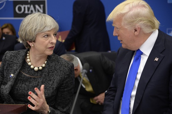 US President Donald Trump, right, speaks with British Prime Minister Theresa May as they participate in a working dinner meeting, during the NATO summit of heads of state and government, at the NATO h ...