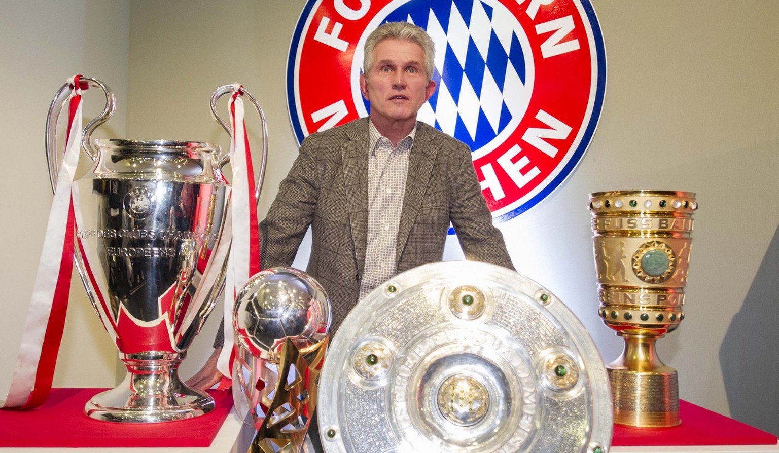 Head coach of Bundesliga soccer club Bayern Munich, Jupp Heynckes, poses with the trophies he and his team have won in the season 2012/2013 from left&gt; Champions League trophy, DFL Supercup trophy,  ...
