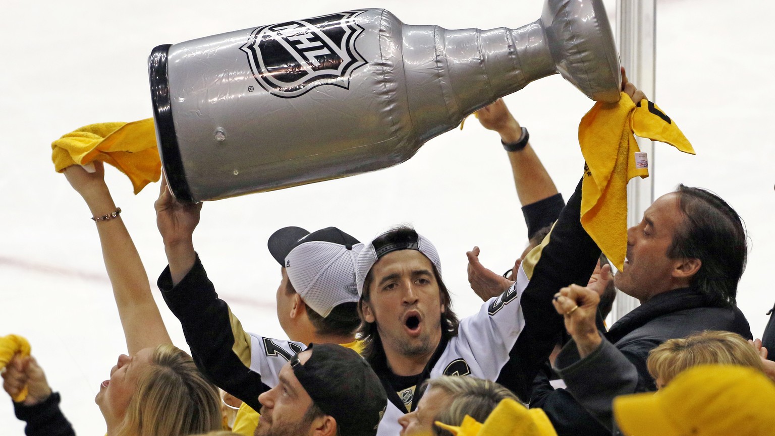 A Pittsburgh Penguins fan holds up an inflatable Stanley Cup as the horn sounds on a 3-2 Penguins win over the Washington Capitals in Game 4 of an NHL Stanley Cup Eastern Conference semifinal hockey g ...