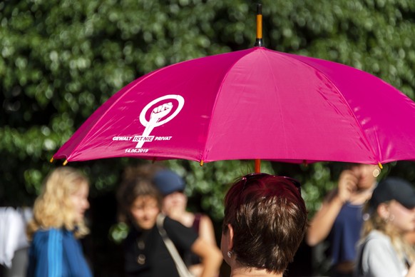 Eine Frau mit der Aufschrift GEWALT IST NIE PRIVAT auf ihrem Schirm nimmt teil am Frauenstreik in Basel, am Dienstag, 14. Juni 2022. (KEYSTONE/Georgios Kefalas)
