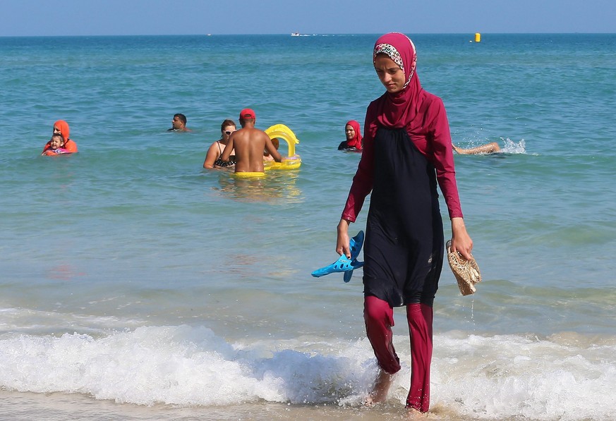 epa05513331 A Tunisian woman wearing a &#039;burkini&#039; walks at beach Bizerte, north-eastern Tunis, Tunisia, 28 August 2016. EPA/MOHAMED MESSARA