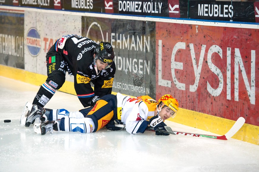 Le joueur fribourgeois Yannick Rathgeb, gauche, lutte pour le puck avec Le Top Scorer zougois Lino Martschini, droite, lors de la rencontre du championnat suisse de hockey sur glace de National League ...