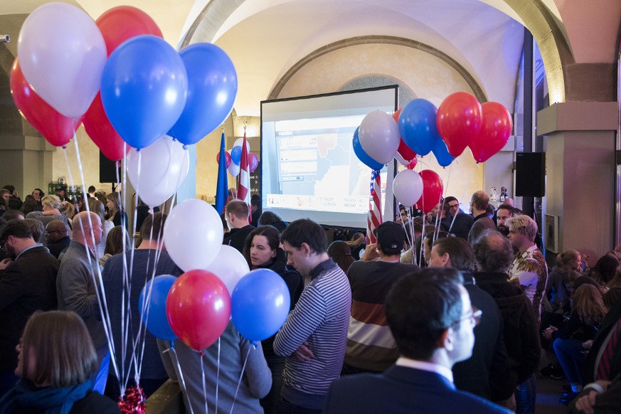 Peoples speak and watch results on the TV screen during an election party organized by the US embassy at the Kornhaus Cafe, Bern, Switzerland, November 9, 2016. US Americans vote on Election Day to ch ...