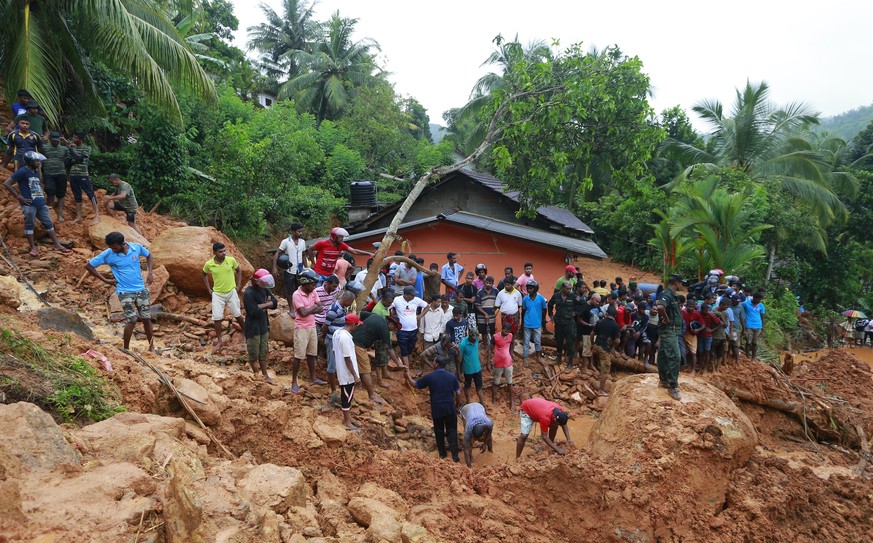 Sri Lankans watch military rescue efforts at the site of a landslide in Bellana village in Kalutara district, Sri Lanka, Friday, May 26, 2017. Mudslides and floods triggered by heavy rains in Sri Lank ...