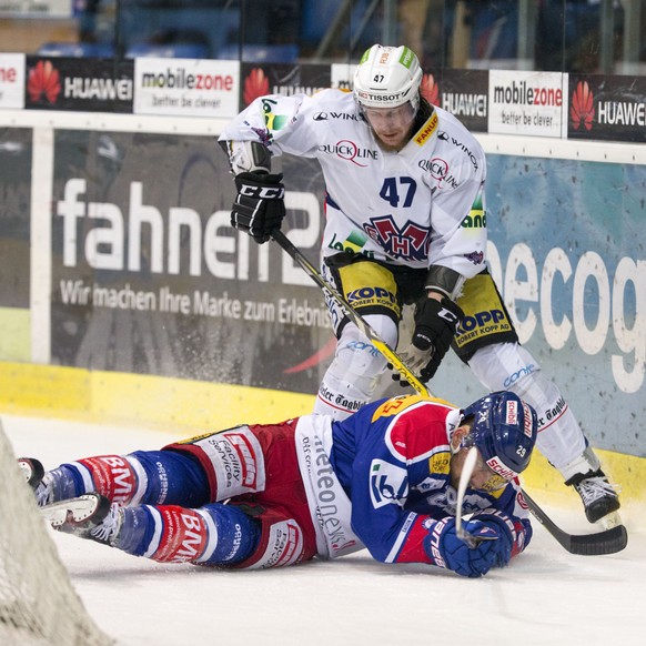 EHC Biel Verteidiger Marco Maurer, stehend, gegen EHC Kloten Stuermer Vincent Praplan waehrend dem Eishockey-Meisterschaftsspiel der National League A zwischen dem EHC Kloten und dem EHC Biel am Samst ...