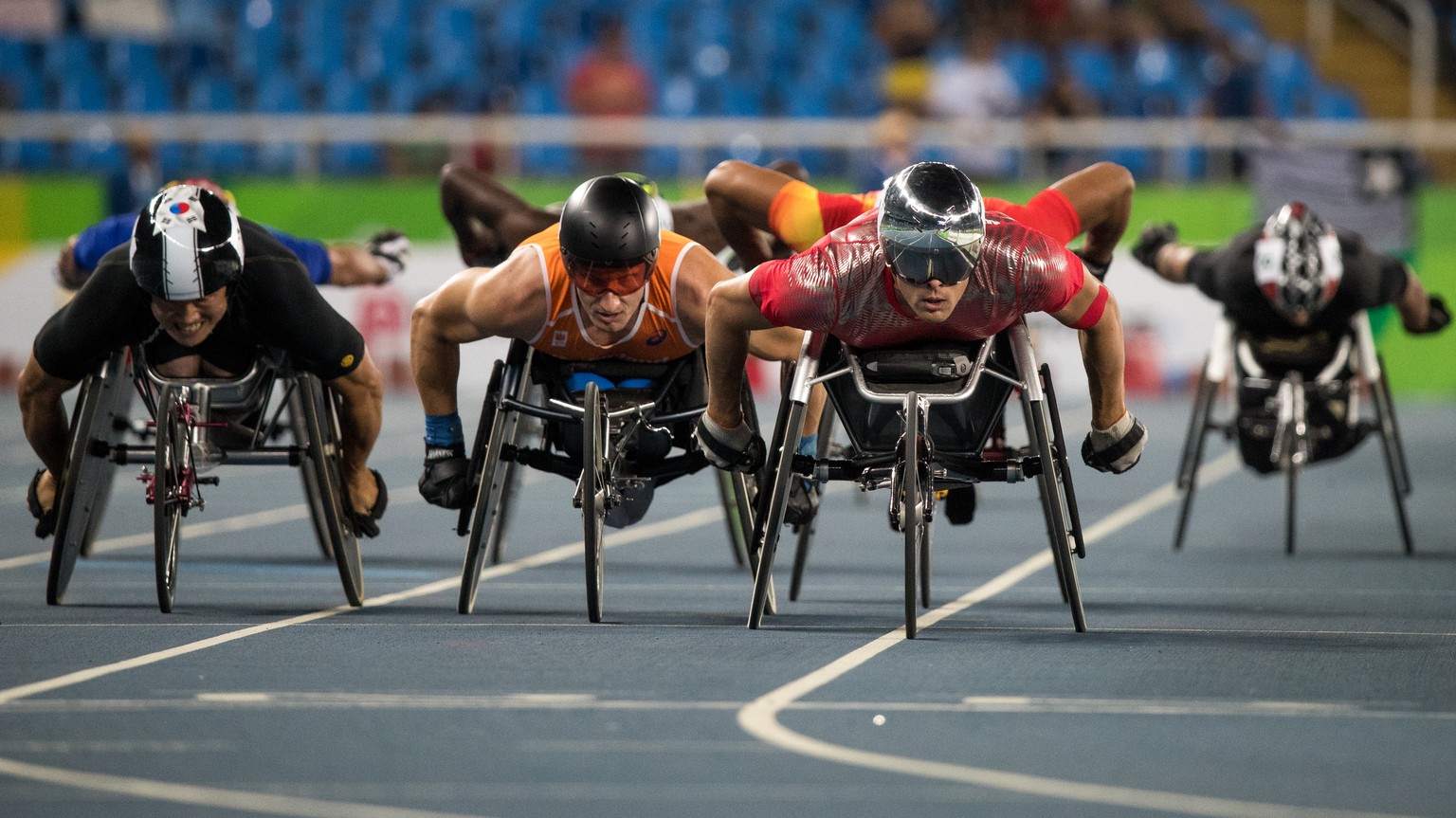 In this photo released by the IOC, Korea&#039;s Gyu Dae Kim, left, Kenny van Weeghel of the Netherlans, second left, and Marcel Hug from Switzerland lead in heat 2 of the men&#039;s 800-meter - T54 at ...